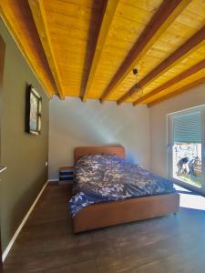 - une chambre avec un lit et un plafond en bois dans l'établissement Villa Pax, à Peje