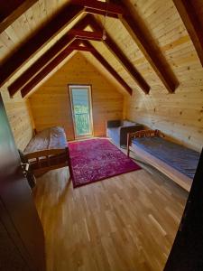 Habitación en el ático con 2 camas y alfombra morada en Villa Pax, en Peje