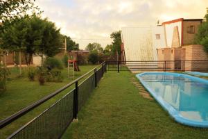 a swimming pool in a yard next to a fence at Tierra Mandarina Cabañas in Gualeguaychú