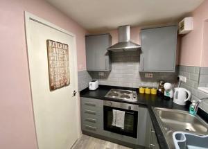 a kitchen with a sink and a stove top oven at Bakers House - Contractor Suitable in Bentley