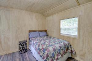 ein kleines Schlafzimmer mit einem Bett und einem Fenster in der Unterkunft Serene Briceville Vacation Rental Cabin with Grill! 