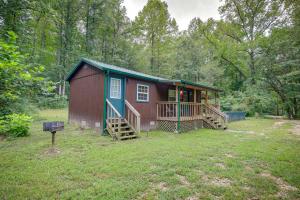 a red and green cabin in the middle of a yard at Serene Briceville Vacation Rental Cabin with Grill! in Briceville