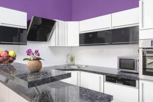 cocina con armarios blancos y encimera de granito en Luxury 3KK Apt w/2KINGBeds 65”TV,Next Wenceslas Sq en Praga