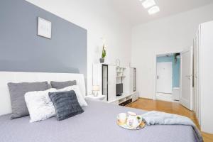 Un dormitorio blanco con una cama con un plato. en Luxury 3KK Apt w/2KINGBeds 65”TV,Next Wenceslas Sq en Praga