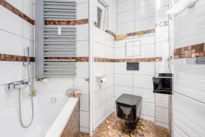 y baño blanco con bañera y ducha. en Luxury 3KK Apt w/2KINGBeds 65”TV,Next Wenceslas Sq en Praga