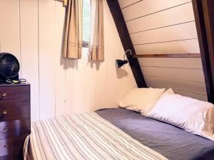 Dormitorio pequeño con cama con cabecero de madera en Sunday Hollow, en Margaretville