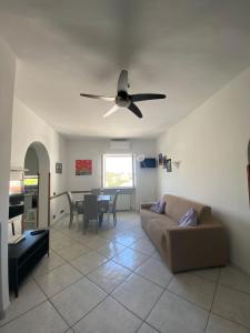 a living room with a couch and a ceiling fan at Casa di Sole Ischia in Ischia