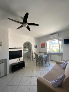 a living room with a couch and a ceiling fan at Casa di Sole Ischia in Ischia