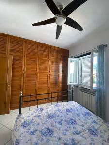una camera con letto e ventilatore a soffitto di Casa di Sole Ischia a Ischia