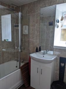 a bathroom with a sink and a shower and a tub at Craigmile Cottage in Fraserburgh
