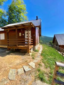 a log cabin with a porch on a hill at Villa Pax in Peje