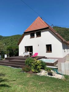 a white house with a deck and a table and chairs at Gîte du Florival in Lautenbachzell