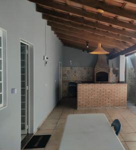 a room with a table and a brick fireplace at Casa ampla e linda com área de lazer in Uberlândia