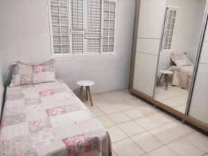 um quarto com uma cama, um espelho e uma cadeira em Casa ampla e linda com área de lazer em Uberlândia