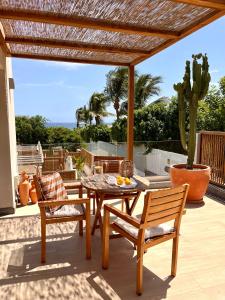 een tafel en stoelen op een patio met uitzicht op de oceaan bij Mangata Gran Canaria - Adults Only in San Agustin