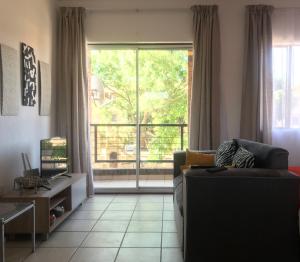 a living room with a couch and a large window at Studio Eazi in Midrand