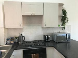 a kitchen with a stove top oven next to a microwave at Studio Eazi in Midrand