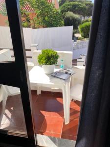 a white table and bench with a plant on a balcony at Alojamento Santa Helena in A dos Cunhados