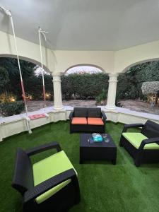 a living room with couches and a table in the grass at Villa With A Private Garden In Beverly Hills in 6th Of October