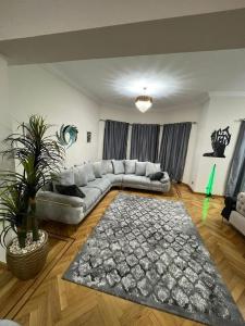 sala de estar con sofá y alfombra en Villa With A Private Garden In Beverly Hills en 6th Of October