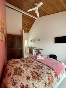1 dormitorio con 1 cama grande y ventilador de techo en Águas da Cachoeira, en Florianópolis