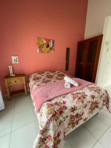 1 dormitorio con 1 cama con pared de color rosa en Águas da Cachoeira, en Florianópolis