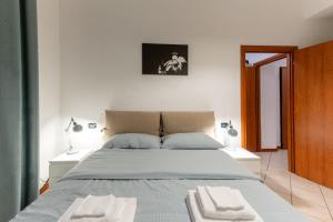 a bedroom with a large bed with two towels on it at Holiday Apartment - Brescia centro - PARCHEGGIO PRIVATO in Brescia