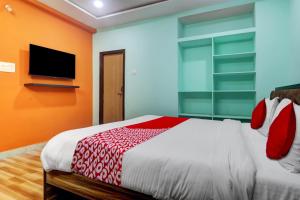 sypialnia z dużym łóżkiem i telewizorem z płaskim ekranem w obiekcie OYO Flagship S Grand Residency w mieście Hajdarabad