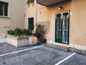 una porta di un edificio con piante in vaso di fronte ad esso di Holiday Apartment - Brescia centro - PARCHEGGIO PRIVATO a Brescia