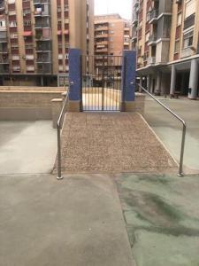 a gate in the middle of a city with buildings at NUEVO! Con piscina a 2 minutos estación tren AVE. in Zaragoza