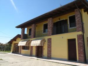 un bâtiment jaune avec un balcon au-dessus dans l'établissement B&B Da Levi Piana Del Sole, à Rivalta Bormida