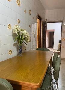 a dining room table with a vase of flowers on it at Casa Mamu en microcentro in Resistencia
