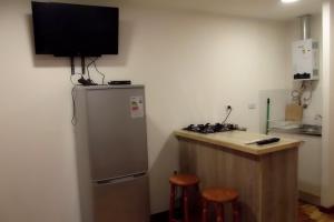 a kitchen with a refrigerator and a counter with stools at CABAÑAS TRAPAGONIA in Coihaique