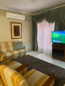 a living room with a couch and a flat screen tv at Casa Mamu en microcentro in Resistencia