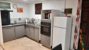 uma cozinha com um frigorífico branco e um micro-ondas em villa do brazil em Ducos