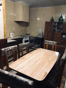 cocina con mesa de madera y algunas sillas en Casa Mirlo en Mendoza