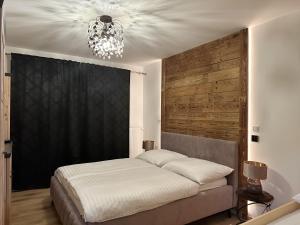 a bedroom with a bed and a chandelier at Apartmány Čerňák - Horňák - 4-6 osob, balkon, dvě parkovací místa in Černý Dŭl