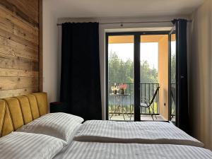 a bedroom with a bed and a view of a balcony at Apartmány Černý důl - Horňák in Černý Dŭl