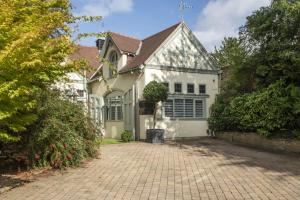 a white house with a brick driveway at Beautiful Secluded 2 Bedroom Coach House in Nottingham