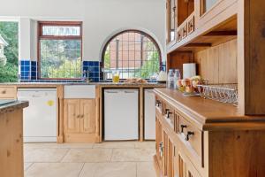 a large kitchen with wooden cabinets and white appliances at Beautiful Secluded 2 Bedroom Coach House in Nottingham