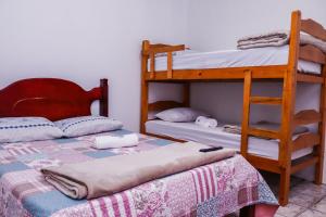 a bedroom with two bunk beds and a ladder at Pousada Bela Vista in Inconfidentes