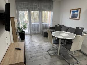 a living room with a table and chairs and a couch at Mifi Apartman Balatonlelle in Balatonlelle