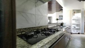 a kitchen with a stove with pots and pans on it at Casa inteira, com sauna, piscina ozonizada, praia Enseada dos Corais, Cabo de Santo Agostinho, Pernambuco, Brasil in Cabo de Santo Agostinho