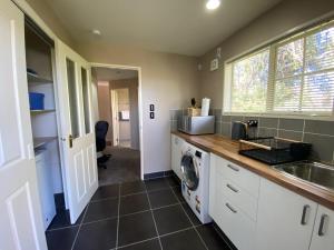 una cucina con lavandino e lavatrice di The Ground Floor Guest Suite a Dunedin
