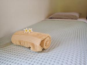 Casa Salvaje Vacation Rentals في بوكاس تاون: سرير عليه منشفة وزهرة