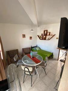 sala de estar con mesa, sillas y TV en Like Home en Salta