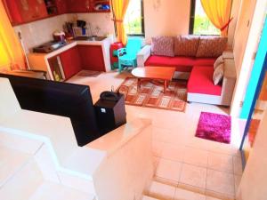 ein Wohnzimmer mit einem Sofa und einem Tisch in der Unterkunft Villa Miky Kota Bunga Puncak Cianjur Bogor in Cinengangirang