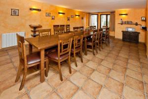 une salle à manger avec une grande table et des chaises en bois dans l'établissement Alojamientos Callejón del Pozo cerca Puy du Fou, à Gálvez