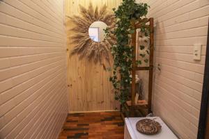 einen Flur mit Tür mit Spiegel und Reben in der Unterkunft Pousada Irreplaceable in Visconde De Maua