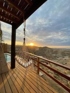 a hammock on a deck with a view of the desert at Casa Natural in Los Órganos